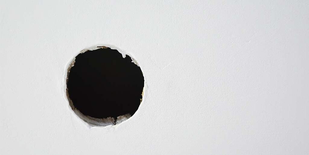 Circular hole in ceiling for hardwired smoke alarm.